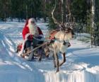 Санта-Клаус на санях с оленями на снегу